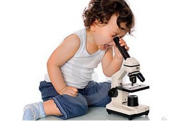 niño mirando en un microscopio